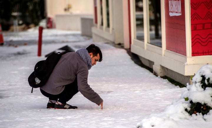 A man touches the snow.