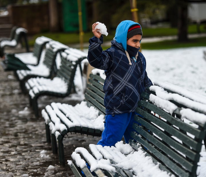 A child prepares to launch a snowball.