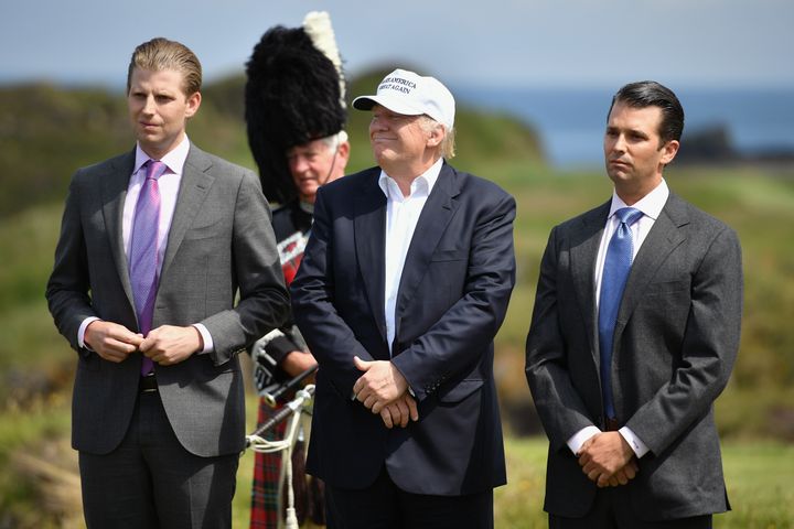 Donald Trump stands with his two sons Donald Trump junior,Eric Trump,following a press conference on the 9th tee at his Trump Turnberry Resort on June 24, 2016.