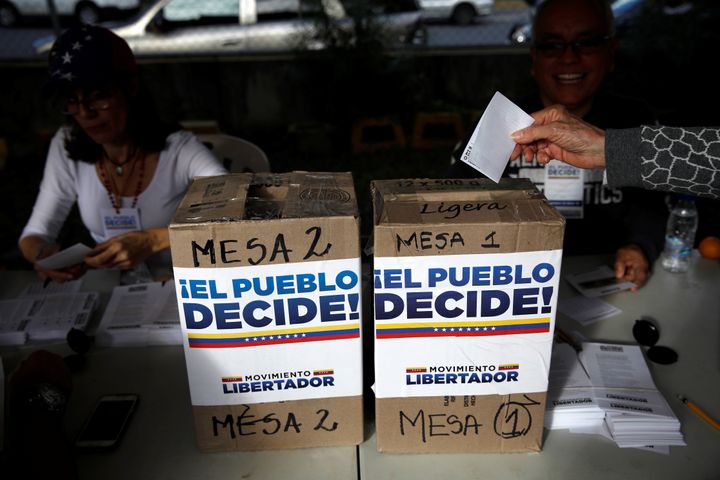 A woman casts her vote during an unofficial plebiscite against Venezuela's President Nicolas Maduro's government. 