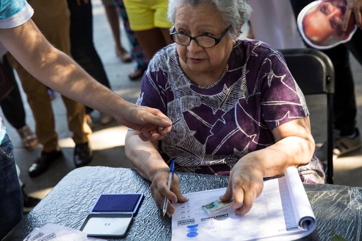 A woman prepares to vote during an unofficial plebiscite against Venezuela's President Nicolas Maduro's government. 