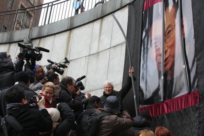 Richard Gere removes the first bar of an art installation at 2010 public event organized by Students for a Free Tibet and Human Rights in China. 