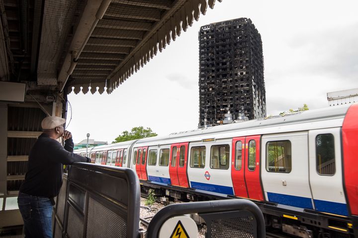 A tube train runs past the remains of the Grenfell Tower, a month after fire engulfed the 24-storey block in Kensington, London