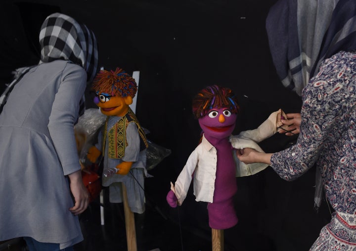 In this photograph taken on July 2, 2017, Afghan puppeteers dress Sesame Street Muppets Zeerak (left) and Zari ahead of recording at a television studio in Kabul.