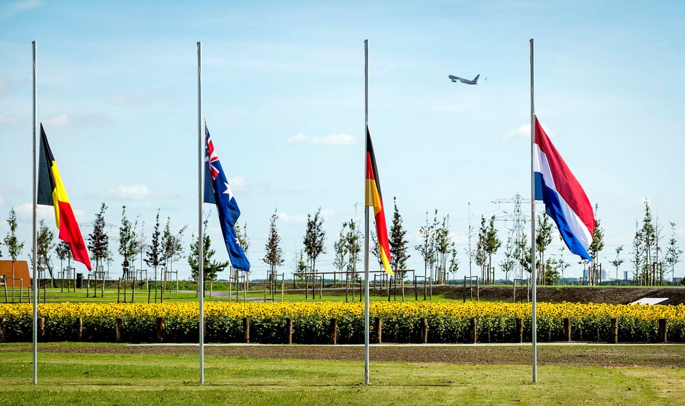 Flags are seen at half mast during an event to unveil a national monument to commemorate the victims of the Malaysia Airlines