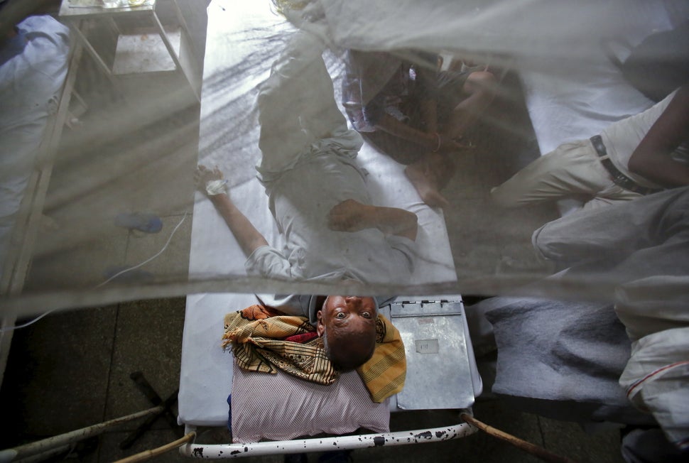A patient awaits a routine check-up as he lies under a mosquito net inside a dengue ward of a government hospital in New Delh