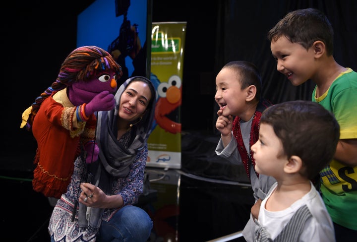 In this photograph taken on July 2, 2017, Afghan children meet Sesame Street Muppet 'Zari' after a recording at a television studio in Kabul. 