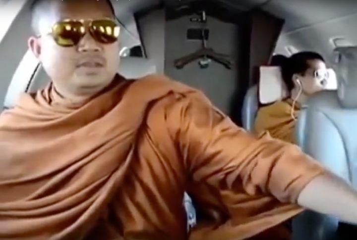 The former monk, wanted on criminal charges, is seen riding in a private airplane in a video released in 2013.