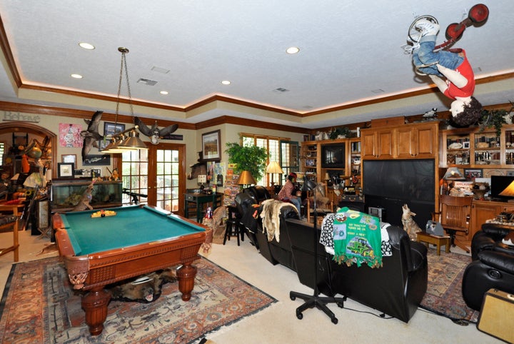 Family room with mannequin on a tricycle hanging from ceiling.