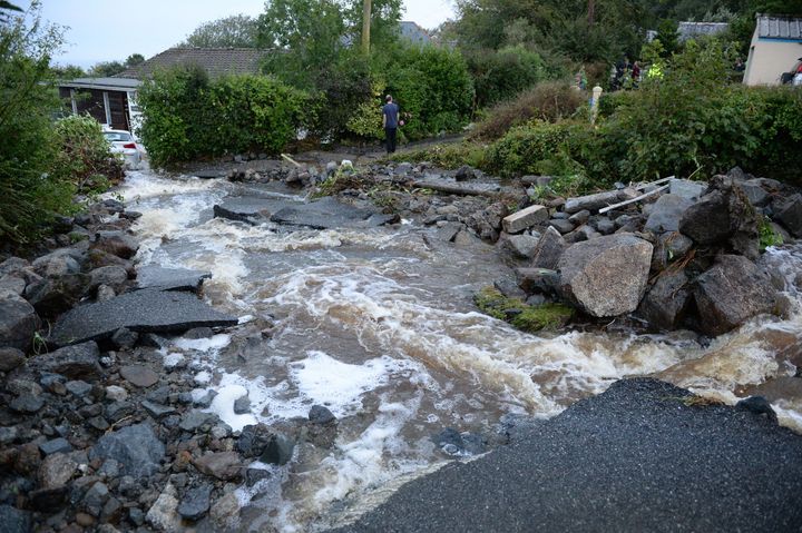 A driveway is lifted caused by water from flash flooding in the coastal village of Coverack in Cornwall.