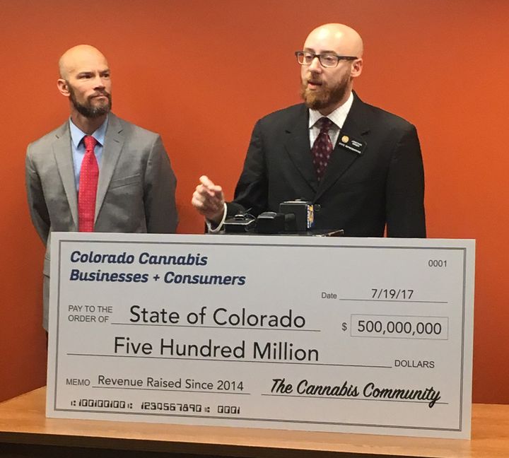 State Rep. Jonathan Singer (D) accepts a novelty check for half a billion dollars from "The Cannabis Community" on Wednesday.