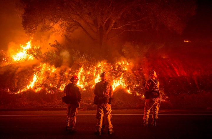 Firefighters monitor flames on the side of a road as the Detwiler Fire rages near the town of Mariposa, California, on July 18.