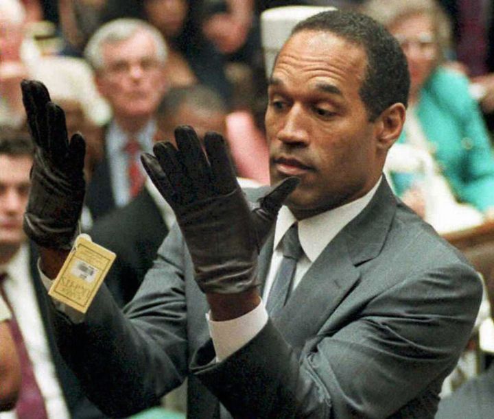 O.J. Simpson looking at a new pair of Aris extra-large gloves that prosecutors had him put on during his double-murder trial in Los Angeles. 1995.