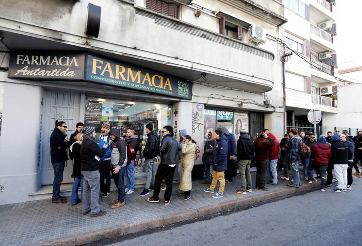 People queue in line outside of a pharmacy to buy legal marijuana in Montevideo, Uruguay July 19, 2017.