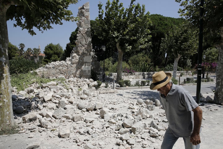 A man walks past debris on the island of Kos