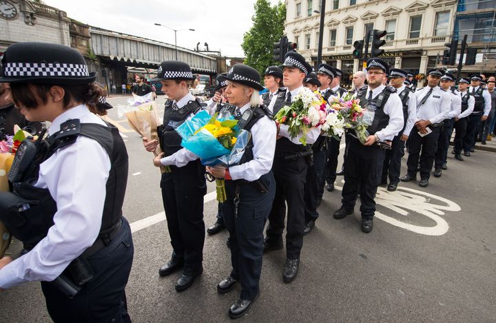 Police officers lay flowers at the scene of the London Bridge attack. Sutherland said he felt survivor's guilt at not being able rush to the scene