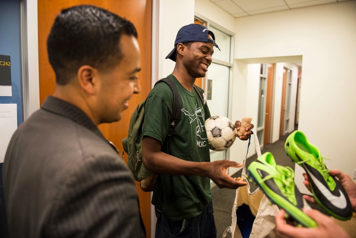 Attorney Cesar Vargas watches as his client Ivan Ruiz is given soccer shoes at the Safe Passage Project offices in Manha