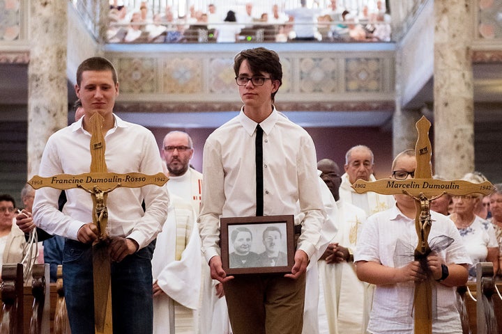 The late couple's great-grandchildren, Jean Udry (L) and Maximilien Udry (C), are seen during Saturday's service.