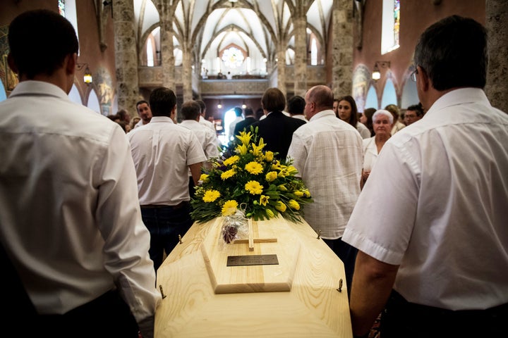 One of the two coffins is seen being carried during Saturday's funeral service. 