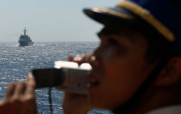 A Vietnamese Coast Guard officer takes a picture of a Chinese Coast Guard ship near Vietnam's central coast. May 14, 2014.