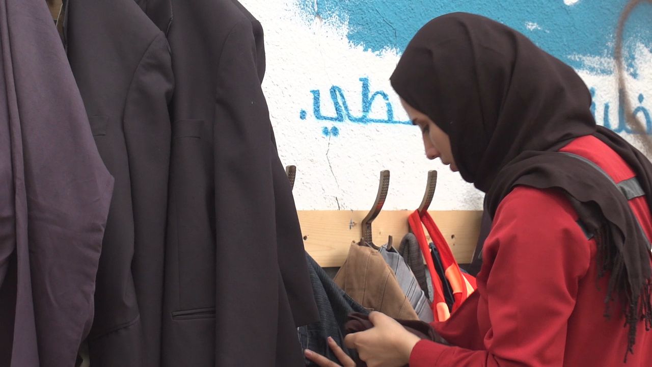 A lady looks at some clothes at the 'wall of kindness'