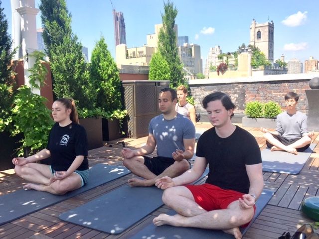 The GlassView team meditates together on the rooftop of their New York office.