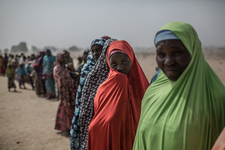 Aisatu with a group of women at the entrance to the displaced people's camp of Muna Garage on the outskirts of Maiduguri, Nigeria. In this camp more than 30 thousand people fleeing from the violence of Boko Haram have sought refuge.