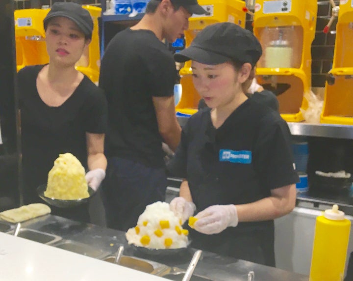 Staff at Ice Monster Kaki Kori creamery put the finishing touches on towers of shaved ice. 