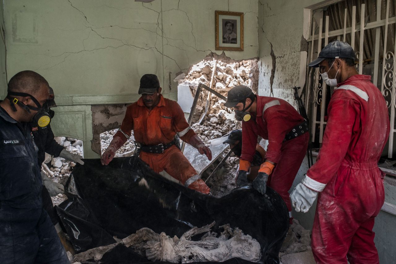 Iraqi Civil Defence workers recover the body of a dead civilian in the destroyed Old City district in Mosul.
