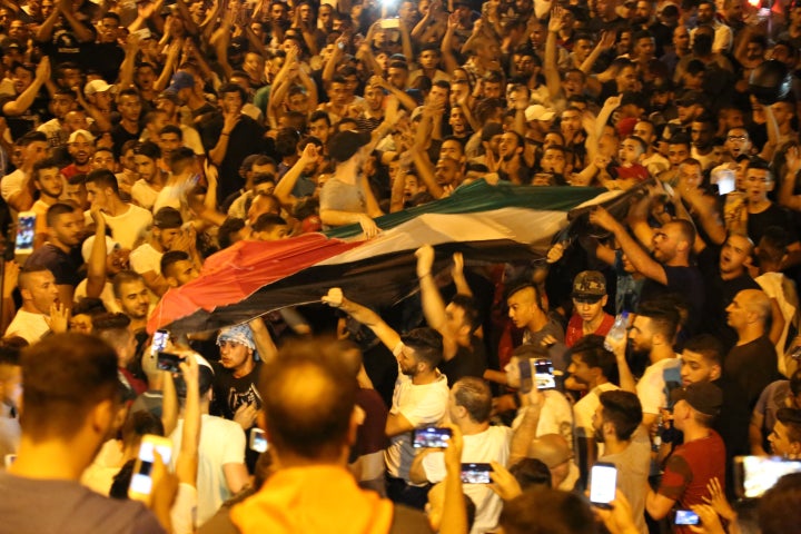 Palestinians celebrate in front of the Lion's Gate entrance to Al Aqsa mosque after more Israeli iron guardrails were removed from the Al-Aqsa Compound in Jerusalem.