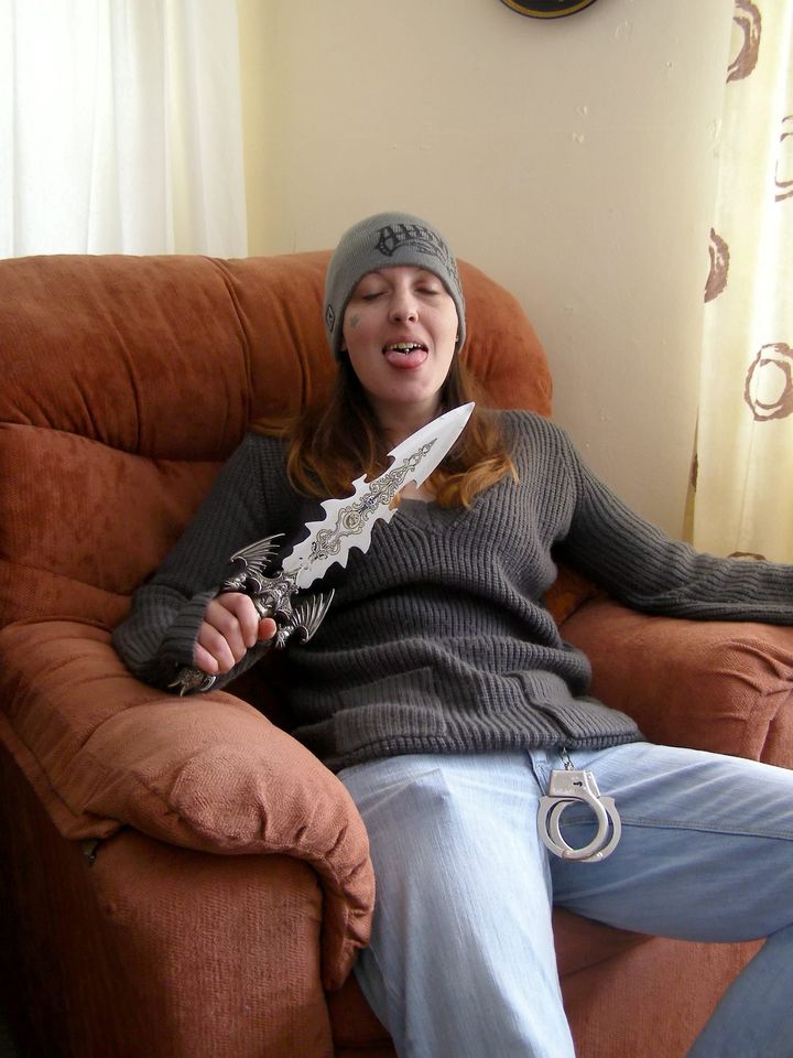 Joanna Dennehy posing with a jagged knife and her tongue protruding