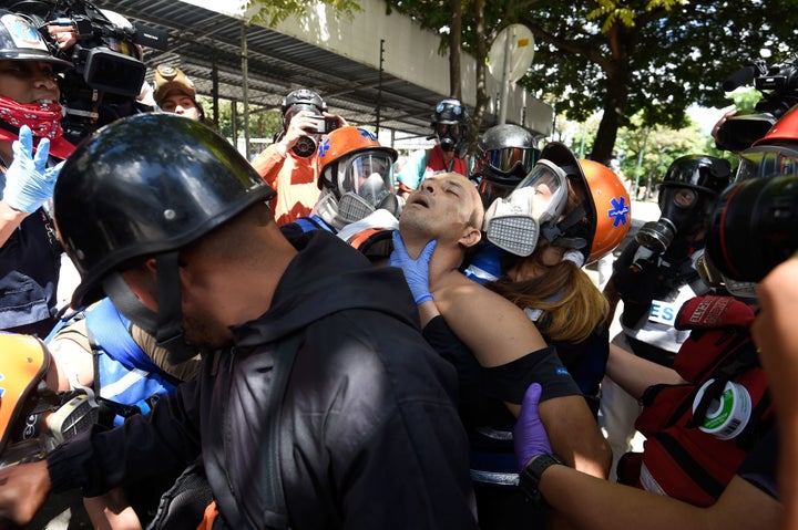 An anti-government activist is assisted and carried away on a motorbike during the opposition's 48-hour general strike i