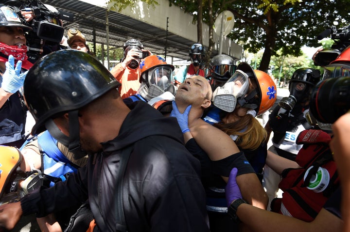 An anti-government activist is assisted and carried away on a motorbike during the opposition's 48-hour general strike in Caracas on July 26, 2017.