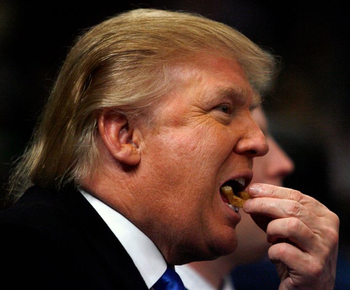 Donald Trump eats a french fry as the New York Knicks play Los Angeles Lakers in the first quarter of their NBA basketball game at Madison Square Garden in New York, January 30, 2007.