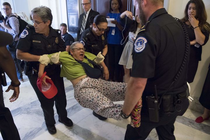 Police arrest a protestor against the Senate Republican's draft healthcare bill outside the office of Senate Majority Leader Mitch McConnell on June 22.