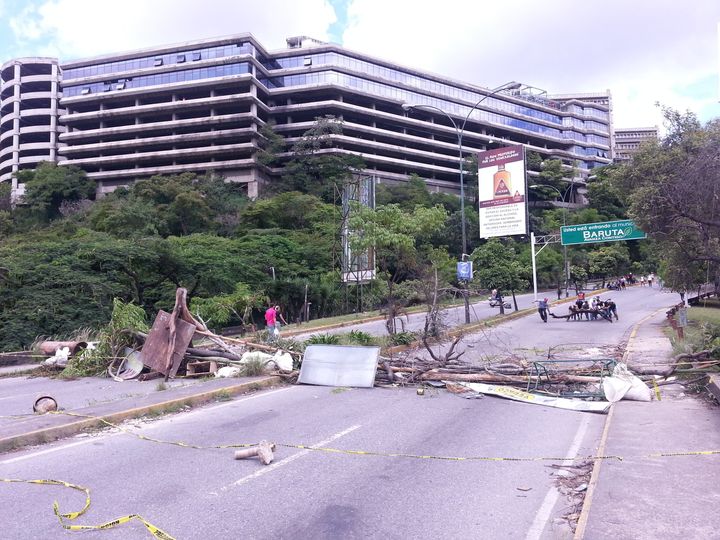 A group of protestors drag a tree trunk toward a barricade in Caracas' eastern neighborhood of Caurimare on Wednesday.