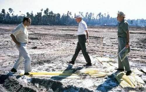 (L – R) Marty Sklar, Welton Becket, and Dick Irvine stand on a giant yellow “X” in late 1968 which marks the spot where Cinderella Castle will eventually be built at WDW’s Magic Kingdom. 