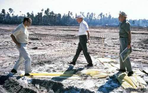 (L – R) Marty Sklar, Welton Becket, and Dick Irvine stand on a giant yellow “X” in late 1968 which marks the spot where Cinde