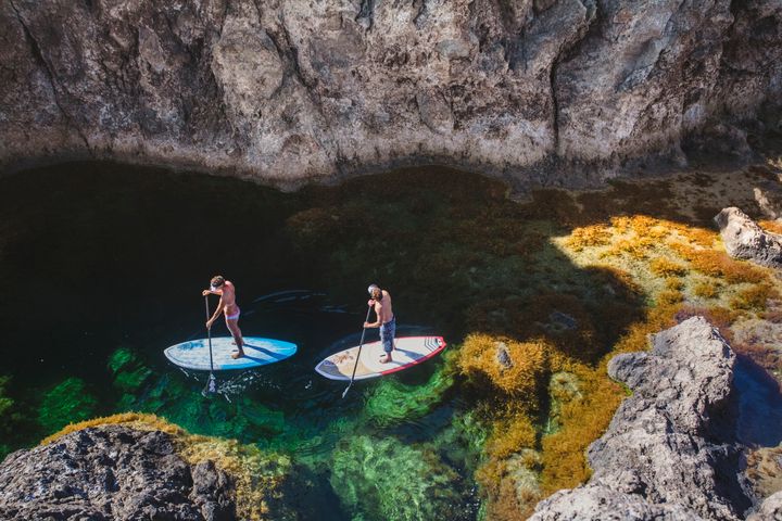 Stand-up paddlers in a natural pool