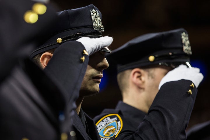 New York Police Department recruits salute during the NYPD graduation ceremony at Madison Square Garden in New York City on December 29, 2015.