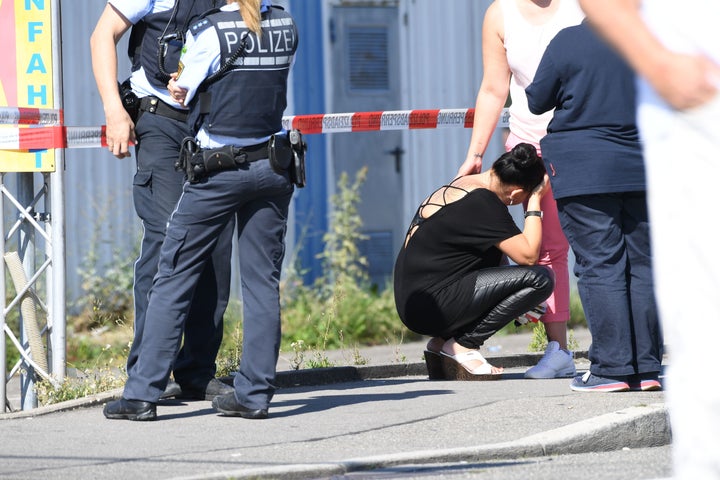 A woman is comforted as police stand by next to the Grey Club.