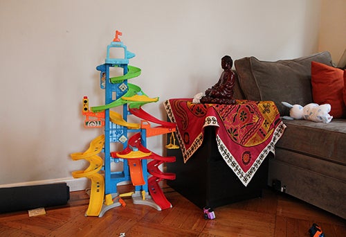 <strong>In the living room: Buddha, yoga mat and child’s toys.</strong>