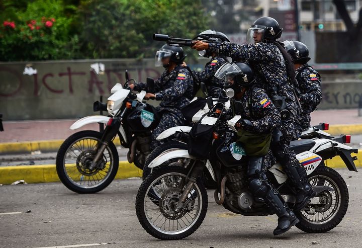 A policeman aims at anti-government activists during clashes which erupted within a protest against the elections for a Constituent Assembly, in Caracas on July 30, 2017. 