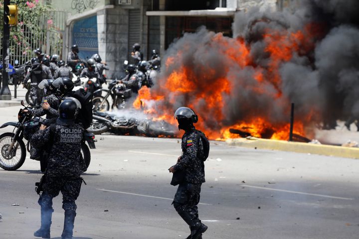 Security forces members stand near burning motorcycles as clashes break out while the Constituent Assembly election is being carried out in Caracas, Venezuela, July 30, 2017. 