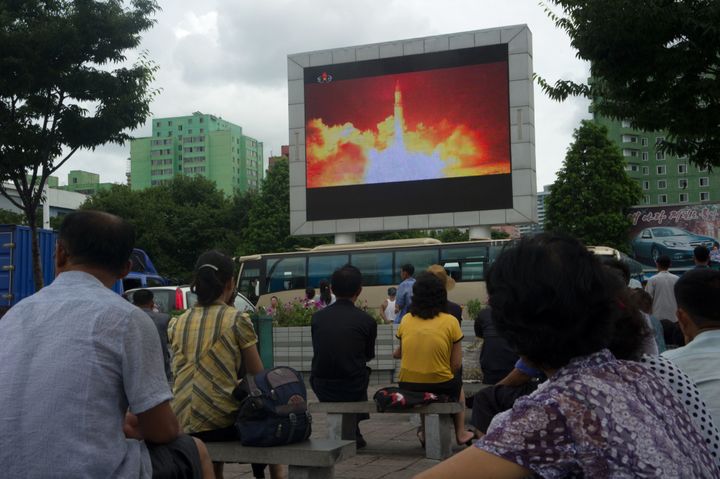 People watch as coverage of an ICBM missile test is displayed on a screen in Pyongyang on Saturday.