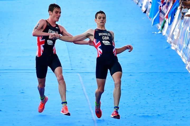 Alistair Brownlee helps his brother, Jonny, over the finish line