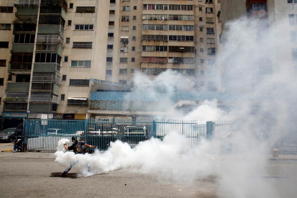 A demonstrator throws back a tear gas canister while clashing with security forces on July 20 in Caracas, Venezuela.