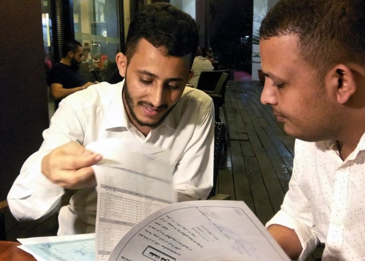 Yemeni Rafek Ahmed Mohammed Al-Sanani (R), 22, and Abdel Rahman Zaid, 26 look through documents as they speak with Reuters in Serdang, on the outskirts of Kuala Lumpur, Malaysia July 20, 2017. 