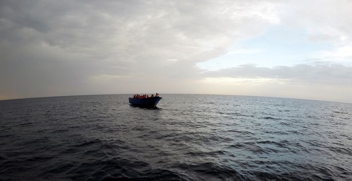 Migrants on a wooden boat wait to be rescued by "Save the Children" NGO crew from the ship Vos Hestia in the Mediterranean sea off Libya coast, June 18.