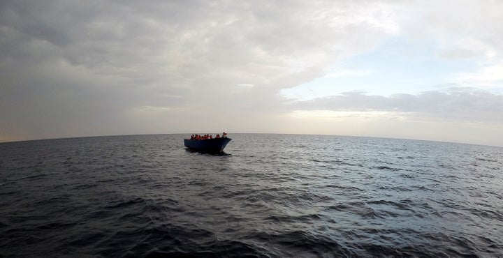 Migrants on a wooden boat wait to be rescued by "Save the Children" NGO crew from the ship Vos Hestia in the Mediterranean sea off Libya coast, June 18.